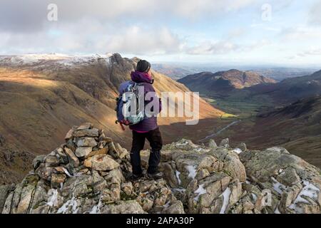 Walker godendo della vista sulla grande Langdale e The Langdale Pikes da est Top di Rossett Pike, Lake District, Cumbria, Regno Unito Foto Stock