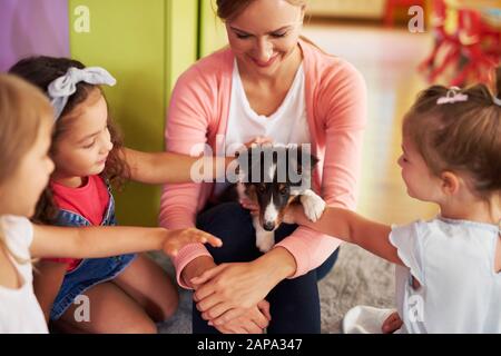 I bambini felici accarezzano il cane carino Foto Stock