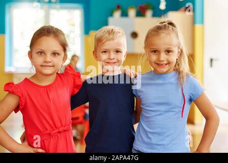 Ritratto di tre bambini sorridenti nella scuola materna Foto Stock
