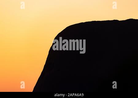 Primo piano silhouette di Uluru al tramonto. Territorio Del Nord, Australia Foto Stock