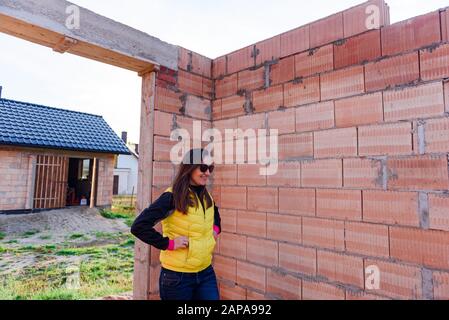 Interno di un semilavorato in mattoni rossi muri di casa in costruzione senza copertura. Foto Stock