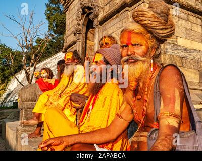 Un gruppo di Sadhus indiani, santi uomini, seduti davanti a un santuario nel tempio di Pashupatinath Foto Stock