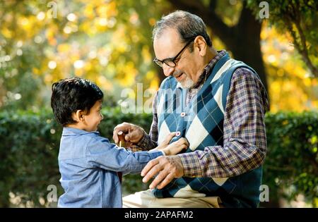 Nonno amorevole che gioca con suo nipote al parco Foto Stock