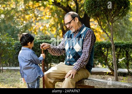 Nonno amorevole che gioca con suo nipote al parco Foto Stock