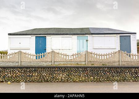 Chiuse capanne da spiaggia terrazzate ben indossate a Fleetwood, Lancashire, Regno Unito Foto Stock