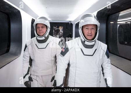 Gli astronauti della NASA Bob Behnken, a sinistra, e Doug Hurley, indossando le spaziali SpaceX, camminano attraverso il braccio Crew Access che collega la torre di lancio al veicolo spaziale SpaceX Crew Dragon durante una prova di vestito presso il Kennedy Space Center della NASA in Florida il 17 gennaio 2020. Una navicella spaziale SpaceX Falcon 9 Rocket and Crew Dragon si trova sulla rampa di lancio del Launch Complex 39A, davanti al test di interruzione In volo senza equipaggio dell'azienda. Il test di volo dimostrerà le capacità di fuga del veicolo spaziale in preparazione dei voli in equipaggio verso la Stazione spaziale Internazionale come parte del Commercial Crew Prog dell'agenzia Foto Stock