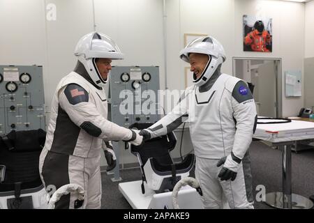 Gli astronauti della NASA Bob Behnken, a sinistra, e Doug Hurley scuotono le mani dopo aver corteggiato negli spacesuits di SpaceX negli Astronauta Crew Quarters al Kennedy Space Center in Florida il 17 gennaio 2020, durante una prova di vestito davanti al test di Abort in volo senza equipaggio della società. Una navicella spaziale SpaceX Falcon 9 Rocket e Crew Dragon si allontanerà dal Launch Complex 39A durante il test di volo, che dimostrerà le capacità di fuga della navicella spaziale in preparazione dei voli in equipaggio verso la Stazione spaziale Internazionale come parte del Commercial Crew Program dell'agenzia. Behnken e Hurley sono uccisi per volare sul c Foto Stock