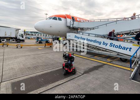 Salite a bordo della rampa Stobart in uso presso l'Aeroporto di Londra Southend per un aereo easyJet con scooter da mobilità. Viaggio aereo accessibile. Disabilità. Accesso Foto Stock