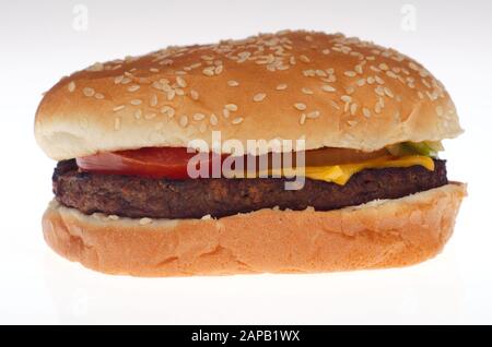 Macro primo piano di un Burger King Impossible Whopper pianta a base di hamburger con seme di sesamo bun, formaggio giallo, pomodoro su sfondo bianco Foto Stock