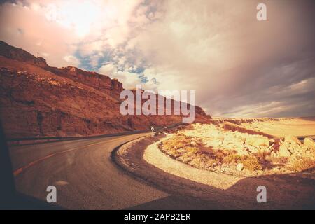 Tortuosa strada di montagna con cielo drammatig. Cratere Makhtesh Ramon nel deserto di Negev al tramonto, Israele Foto Stock