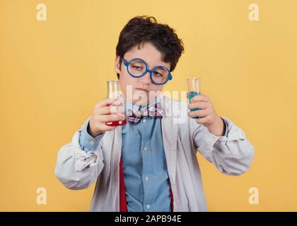 Bambino scienziato in laboratorio su sfondo giallo Foto Stock