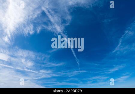 Bianco lanuginoso cirrocumolo e cirrus nuvole in blu profondo azzurro cielo e luce del sole. Estate buon tempo concetto di fondo. Foto Stock