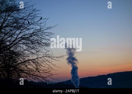 fumo camino all'alba in inverno Foto Stock