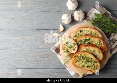 Piatto con pane all'aglio tostato e aneto su fondo in legno, vista dall'alto Foto Stock