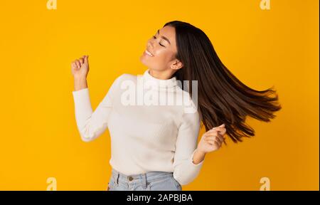 Ragazza asiatica che balla e che si imbrogliano con i capelli Foto Stock