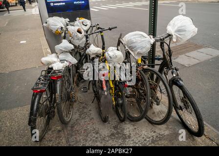 Consegna biciclette parcheggiate nel quartiere Chelsea di New York il martedì 14 gennaio 2020 riutilizzare i sacchetti di plastica come isolamento e protezione dalle intemperie. Il divieto dello Stato di New York sui sacchetti di plastica monouso avrà effetto a marzo 2020. (© Richard B. Levine) Foto Stock