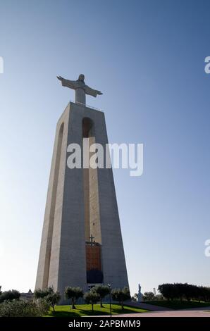 Santuario Nazionale di Cristo Re ad Almada, costruito nel 1959, di fronte a Lisbona e al fiume Tago. Vista dalla parte anteriore in basso contro un cielo blu chiaro. Portoghese Foto Stock