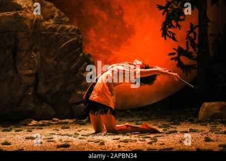 Barbican Theatre, Londra, 22nd Gen 2020. Maria Carolina Vieira esegue una scena mozzafiato con una pistola di fronte a una luna gigante. Il gruppo belga Peeping Tom esplora le percezioni dell'infanzia, usando danza, umorismo e coreografia fisica del teatro nella loro produzione chiamata Child (Kind). Parte del London International Mime Festival 2020, 'Peeping Tom - Child (Kind) corre al Barbican Theatre Jan 22nd-25. Credito: Imageplotter/Alamy Live News Foto Stock