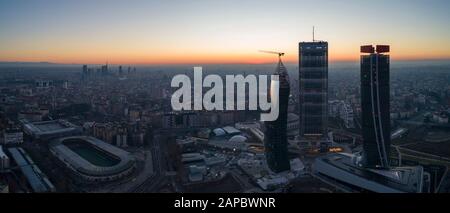 Skyline di Milano all'alba, vista aerea. I nuovi 3 grattacieli (chiamati il rettilineo, il curvo e il tortuato) del quartiere Citylife all'alba. Foto Stock