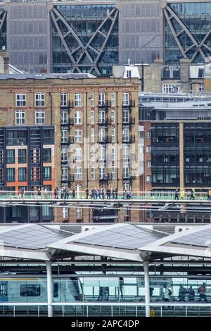 Londra. Blackfriars Railway Bridge e la stazione ferroviaria, il Millennium pedonale bridge e gli edifici del quartiere finanziario della City of London. Foto Stock