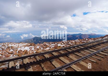 I percorsi in treno si trovano sulla cima innevata di Pikes Peak e si affacciano su una vista incredibile del paesaggio sottostante. Foto Stock