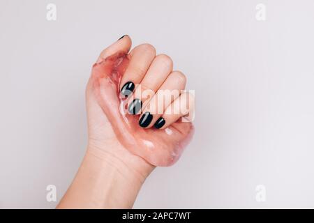 Mani con manicure nero trasparente di contenimento limo Foto Stock