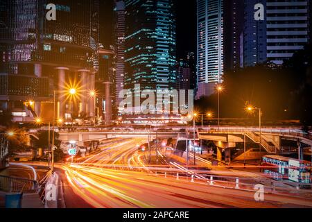 Traffico cittadino di notte, percorsi leggeri di auto sulla strada a Hongkong Foto Stock