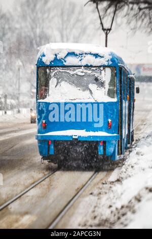 Il tram cittadino attraversa la neve. Sfondo invernale di Zagabria, Croazia. Foto Stock