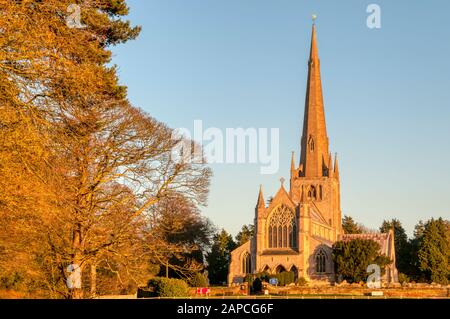 La luce del sole serale si trova nella parte anteriore occidentale della chiesa di Santa Maria a Snettisham. Pevsner lo chiamò 'forse la chiesa Decorata più emozionante in Norfolk'. Foto Stock
