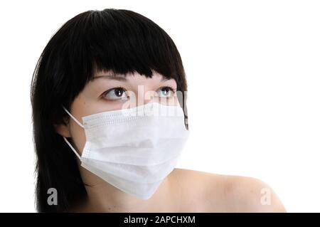 primo piano ritratto di giovane donna in maschera medica protettiva su sfondo bianco, isolato Foto Stock