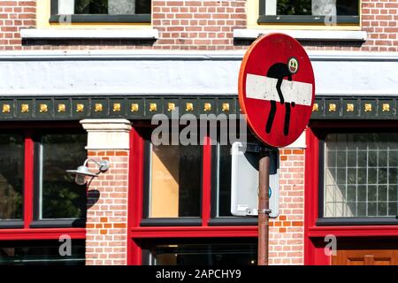 Segnale di traffico divertente -ingresso vietato- nella città di Alkmaar. Un maschio vuole rimuovere il segnale di traffico. Foto Stock