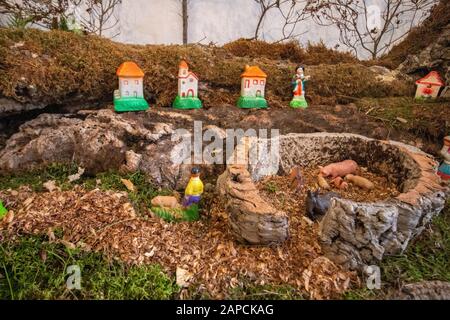 Vista ravvicinata di molte figurine molto piccole che creano una grande ricreazione della scena di presepio. Foto Stock