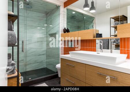 Bagno moderno con piastrelle arancioni e cabina doccia Foto Stock