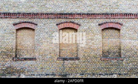 Tre finestre di una vecchia casa sono calci Foto Stock