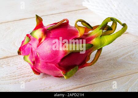 Frutti di drago interi o pitaya su un tavolo di legno bianco. Frutta e verdura. Sano cibo vegetariano ricco di vitamine B e tannino. Vista frontale. Foto Stock