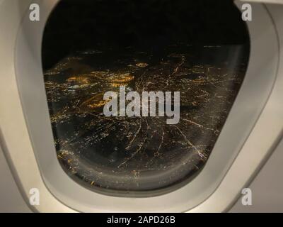 Vista notturna fuori dalla finestra dell'aereo sopra illuminare la città di Amburgo - Germania Foto Stock