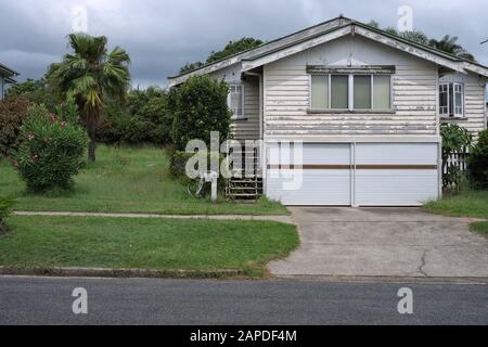 Terreno erboso vuoto troppo coltivato accanto a una casa dei lavoratori del Weatherboard del dopoguerra degli anni '1950 a Cannon Hill, Brisbane Foto Stock