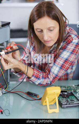 una donna che prova una scheda madre Foto Stock