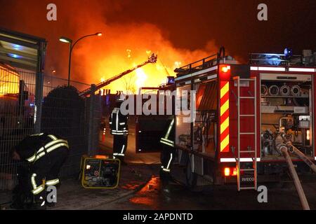 Ilsfeld, Germania. 22nd Gen 2020. I vigili del fuoco cercano di estinguere pile di pallet in legno bruciati. Un incendio distrusse completamente un edificio di una società di pallet nel distretto di Heilbronn e causò danni materiali per circa 2,5 milioni di euro. Credito: Andreas Rosar/Dpa/Alamy Live News Foto Stock