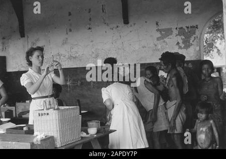 Croce rossa a Medan Descrizione: Arnhemia: La popolazione - forzata evacuata dal TNI per la liberazione della città e finalmente liberata dalle truppe olandesi - ritornata in una condizione più che miserabile nella loro città natale. Qui furono accolti dalla Croce Rossa Olandese e ricevettero rifugio, abbigliamento, cibo e, soprattutto, cure mediche urgenti. Medici e infermieri specializzati aiutano le centinaia di pazienti: Lambosia, malaria, edema, berrie-berrie. Data: 8 Ottobre 1947 Località: Arnhemia, Indonesia, Indie Orientali Olandesi, Sumatra Foto Stock