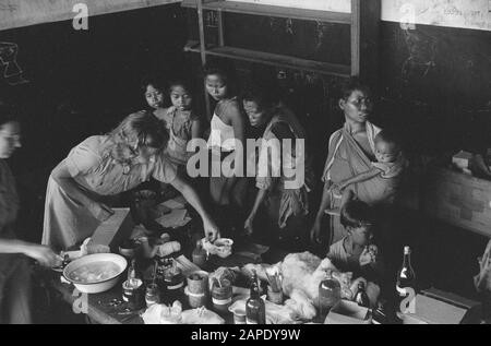 Croce rossa a Medan Descrizione: Arnhemia: La popolazione - forzata evacuata dal TNI per la liberazione della città e finalmente liberata dalle truppe olandesi - ritornata in una condizione più che miserabile nella loro città natale. Qui furono accolti dalla Croce Rossa Olandese e ricevettero rifugio, abbigliamento, cibo e, soprattutto, cure mediche urgenti. Medici e infermieri specializzati aiutano le centinaia di pazienti: Lambosia, malaria, edema, berrie-berrie. Data: 8 Ottobre 1947 Località: Arnhemia, Indonesia, Indie Orientali Olandesi, Sumatra Foto Stock