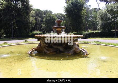 Fontana immersa nel verde nel giardino di Villa Borghese a Roma Foto Stock