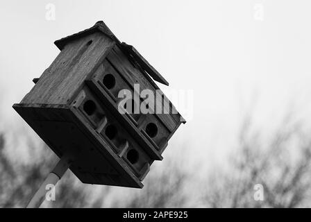 Primo piano di una piccola casa di legno fatta per gli uccelli inclinato in una direzione Foto Stock