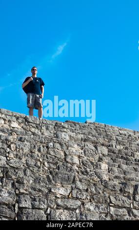 Turismo in cima alla rovina Maya a Dzibilchaltun, Yucatan, Messico Foto Stock