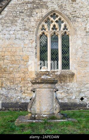 Lapide cilindrica nel cortile di San Michele e nella Chiesa Di tutti gli Angeli. Withington, Gloucestershire, Inghilterra Foto Stock
