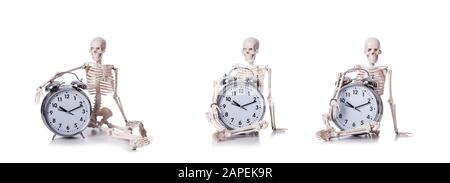 Lo scheletro con la sveglia sul bianco Foto Stock
