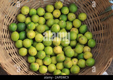 Limette all'interno di un cesto in tessuto di Mullik Ghat Foto Stock