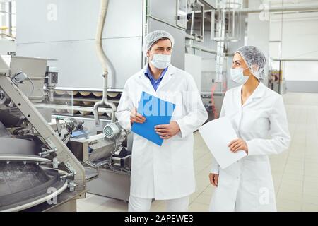 I tecnologi ispettore nelle maschere presso stabilimento alimentare. Foto Stock