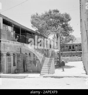 Israele 1964-1965: Gerusalemme (Gerusalemme), Mea Shearim Descrizione: Cortile con accesso tramite scale alle case sul piano Annotazione: MEA Shearim, chiamato anche Meah Shearim o cento porte, è uno dei quartieri più antichi di Gerusalemme. Fu costruito a partire dal 1870 da ebrei asiatici che vivevano nella Città Vecchia fino ad allora. Tuttavia, c'era troppo poco spazio e così comprarono un pezzo di terra a nord-ovest della città. Questa terra, un'area paludata, fu coltivata in terra per costruire un nuovo quartiere: Meah Shearim. Il distretto è noto anno 2012 come il più estremo quartiere ebraico ortodosso del mondo AN Foto Stock