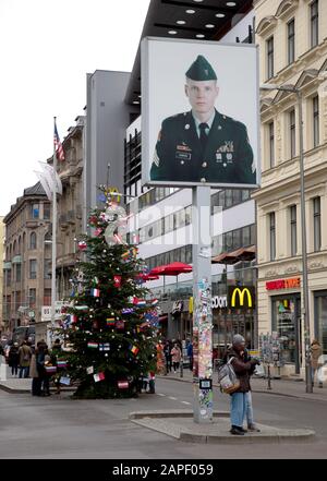 Berlino, Germania - 20 dicembre 2019: la gente visita famoso Checkpoint Charlie a Berlino. Durante la Guerra fredda era il più noto che attraversa Berlino Wa Foto Stock